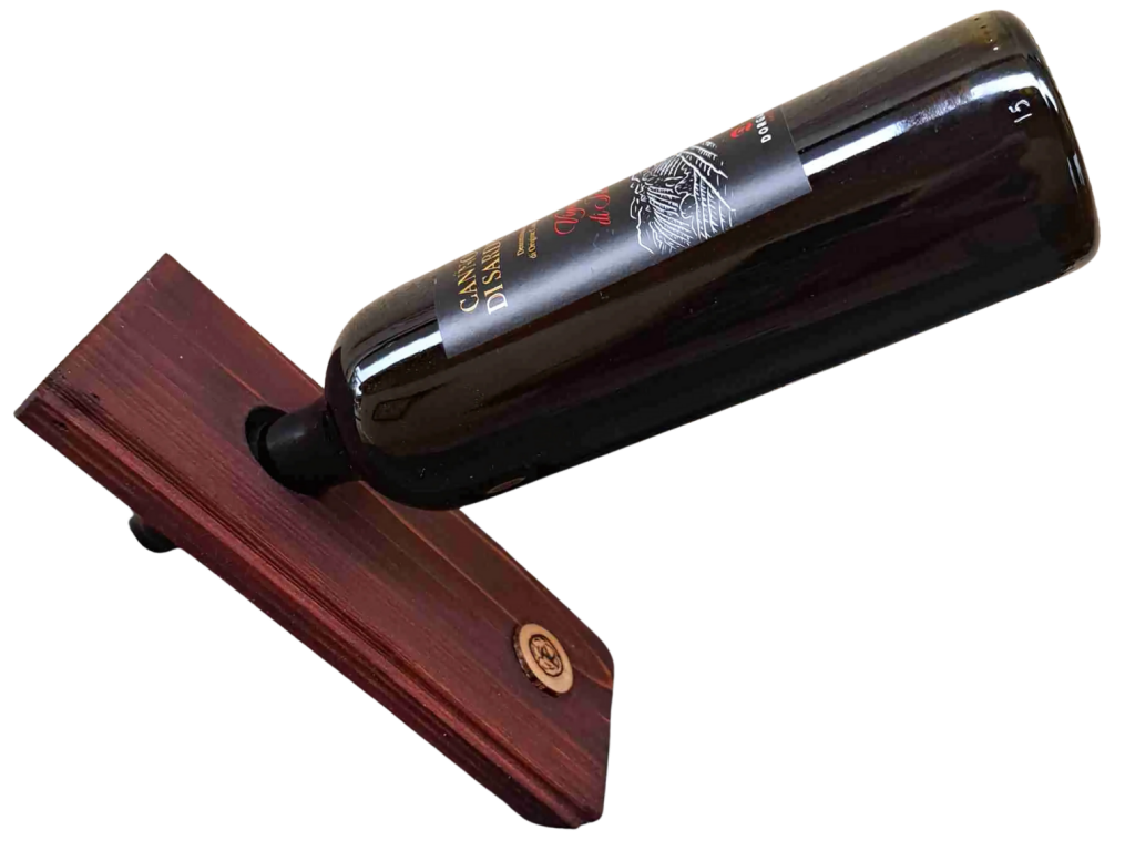 Eine Weinflasche, die schräg auf einem Holzständer platziert ist, mit einem Etikett und einem dunklen Glas.